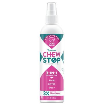 A white plastic spray bottle of Tropiclean Chew Stop Behavior Aid for dogs, featuring a pink and teal label with white text.