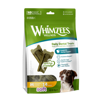 A package of Whimzees Soft Medium dental dog treats. The package is green and white with an image of a dog and the product visible through a transparent window.