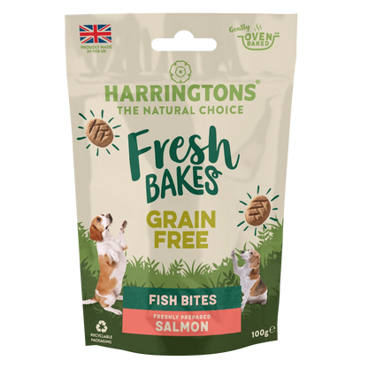 A 100g stand-up pouch of Harringtons Fresh Bakes Grain Free Fish Bites (Salmon flavor) for dogs. The packaging features a beige background with green and yellow text, illustrations of two beagle dogs jumping, and a green bottom section.
